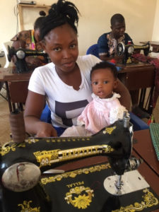 Woman holding her child learning to sew