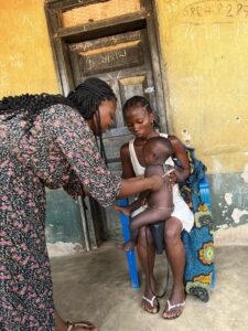 RHCI Nutritionist Umu Shour evaluating a child for malnutrition.