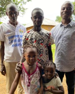 Staff member Moses with family at outreach clinic